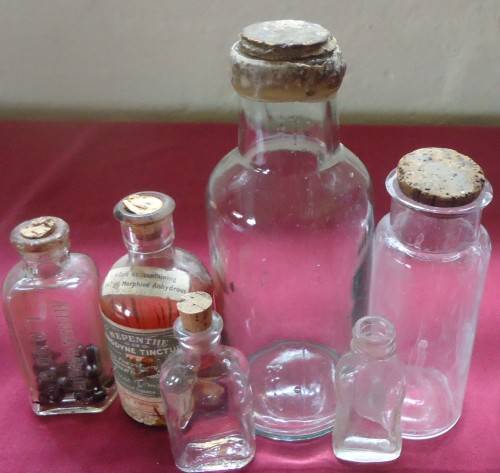 SIX DIFFERENT SIZE VINTAGE CLEAR CHEMIST-APOTHECARY BOTTLES WITH CORK STOPPERS- SEE PHOTOS