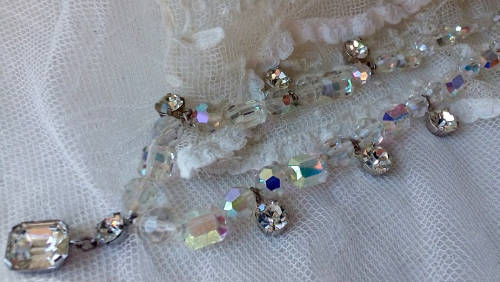 A SPARKLING SINGLE STRAND CRYSTAL NECKLACE WITH 6 SIDE DROP CRYSTALS AND A CENTRAL DROP PENDANT