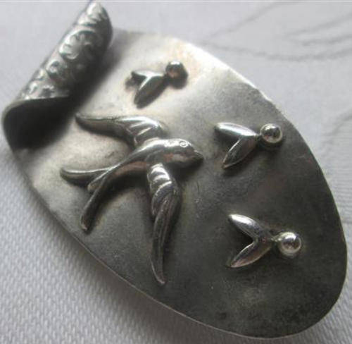 VINTAGE SILVER BROOCH WITH BIRD,  AND EMBOSSED FLORAL DESIGN ON THE REVERSE..