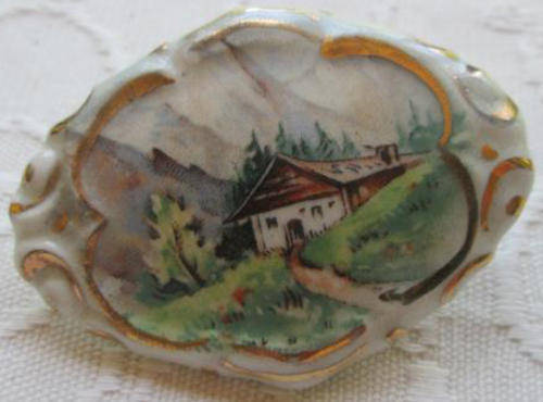 VINTAGE PORCELAIN BROOCH WITH AN ALPINE SCENE.