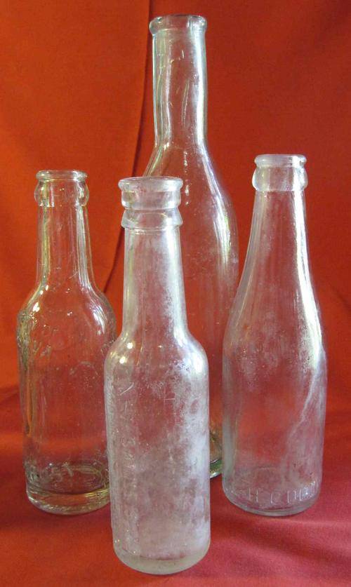 Four Clear Pressed Glass Bottles by Various Makers
