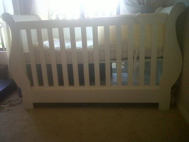 Wooden baby cot with a free compactum, mattress and other accessories thrown in