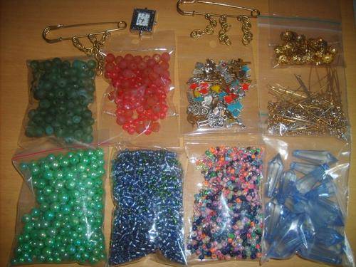 Selection of beads, charms etc, jewelry making book and jewelry stand