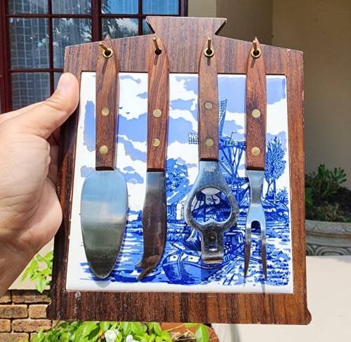 A DUTCH CERAMIC PLATE UTENSIL HOLDER WITH PRONGED CHEESE KNIFE AND SKEWER