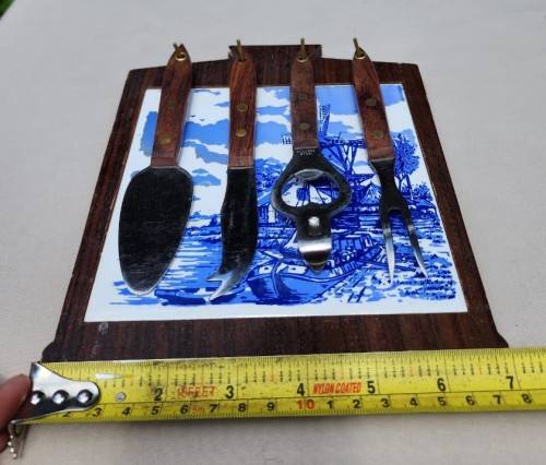A DUTCH CERAMIC PLATE UTENSIL HOLDER WITH PRONGED CHEESE KNIFE AND SKEWER