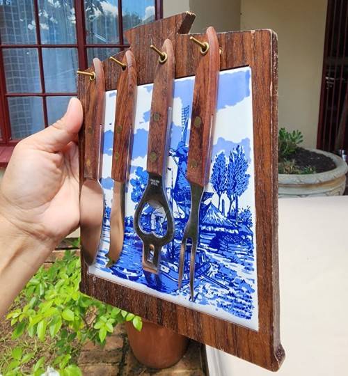 A DUTCH CERAMIC PLATE UTENSIL HOLDER WITH PRONGED CHEESE KNIFE AND SKEWER
