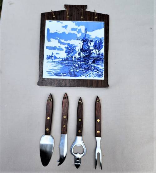 A DUTCH CERAMIC PLATE UTENSIL HOLDER WITH PRONGED CHEESE KNIFE AND SKEWER