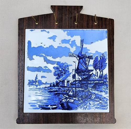 A DUTCH CERAMIC PLATE UTENSIL HOLDER WITH PRONGED CHEESE KNIFE AND SKEWER
