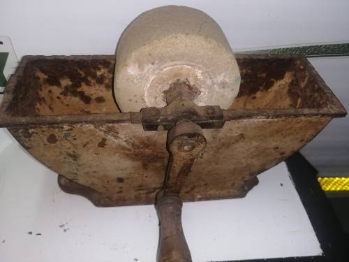 Grinding stone in cast iron holder with handle - very old and with some damage