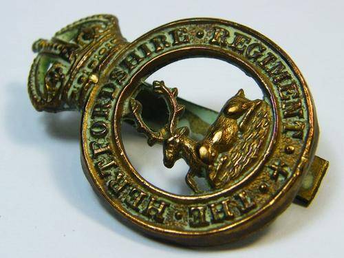 The Hertfordshire regiment cap badge with slide - as per photo