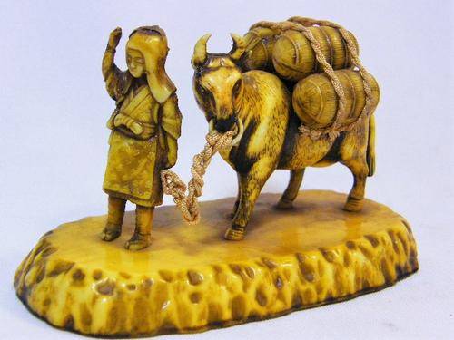 Vintage hard plastic celluloid figure of man and cow carrying barrels - as per photo
