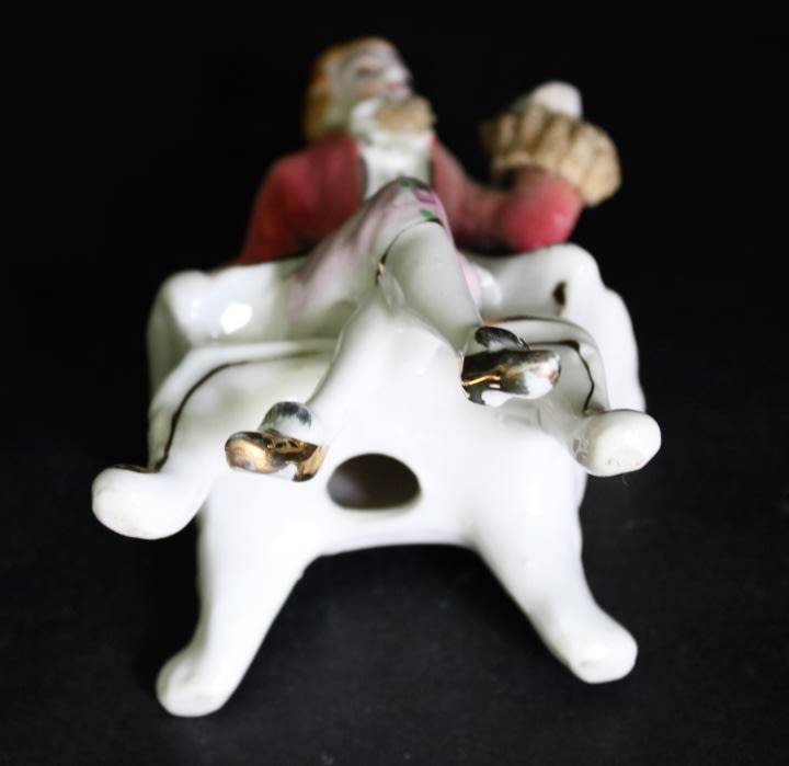 Porcelain Figurine of Man on Seat.