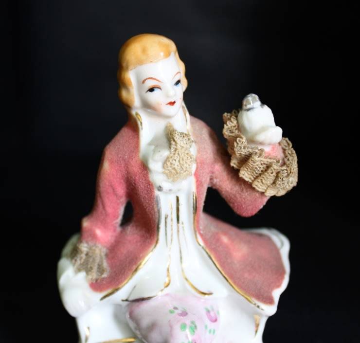 Porcelain Figurine of Man on Seat.
