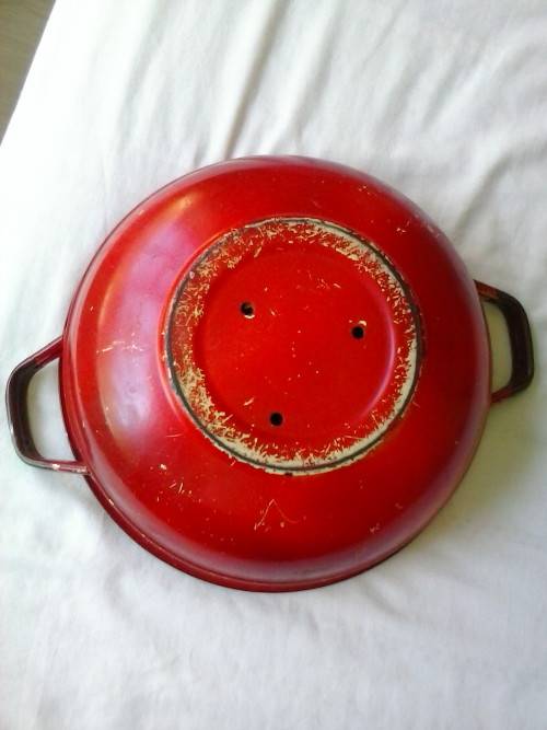 Enamel dish that was used as a flower pot. It has three holes in the bottom.