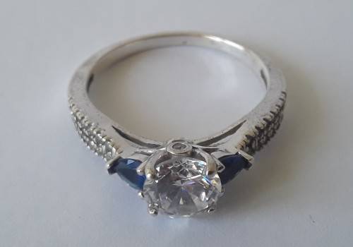 Solid sterling silver trilogy ring with clear centre stone and blue side stones. Size: N (17mm)