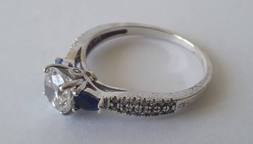 Solid sterling silver trilogy ring with clear centre stone and blue side stones. Size: N (17mm)