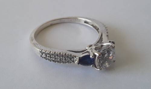 Solid sterling silver trilogy ring with clear centre stone and blue side stones. Size: N (17mm)