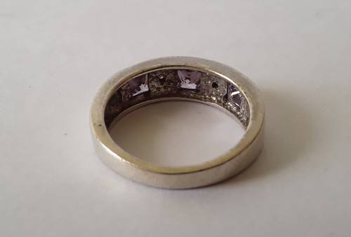 Solid sterling silver band ring with flush set purple stones. Size: N (17mm)