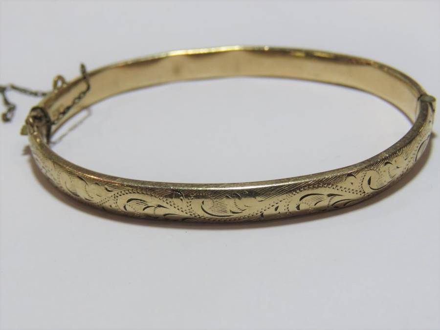 9+kt Gold Metal Core bangle with safety chain - Chain is loose - Some dents inside - Weighs 6.0 gram