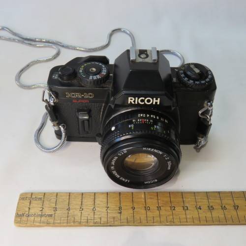 Ricoh KR-10 camera in pouch with Rikenon 1:2 50 mm lens and booklets