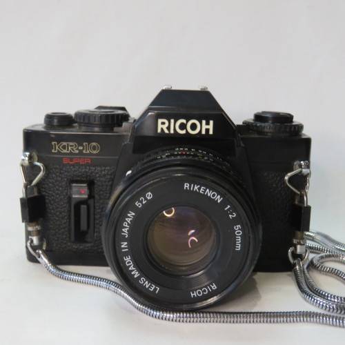Ricoh KR-10 camera in pouch with Rikenon 1:2 50 mm lens and booklets