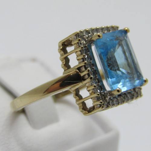 9kt Gold ring with 3.5ct blue topaz and small diamonds of 0.28ct in total - weighs 4.8g - size O/7