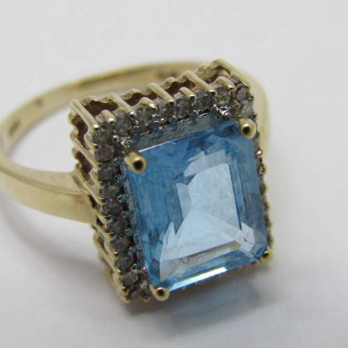 9kt Gold ring with 3.5ct blue topaz and small diamonds of 0.28ct in total - weighs 4.8g - size O/7