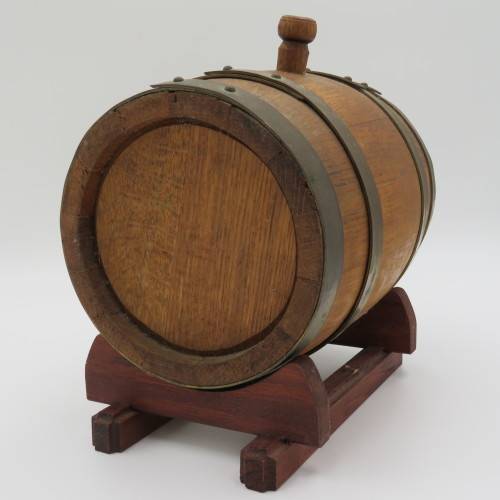 Vintage wooden wine barrel on stand with brass tap