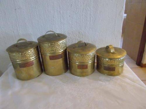 a set of four brass storage containers