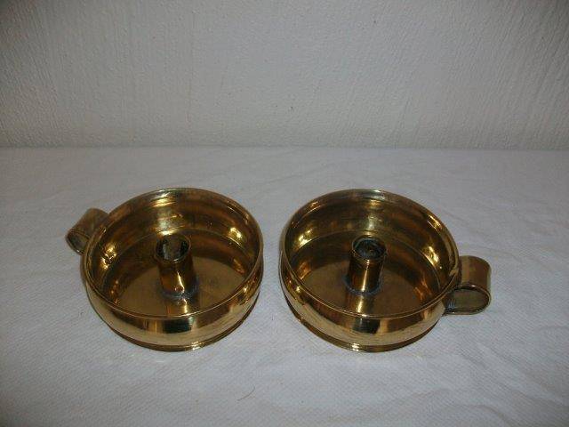 A pair of brass round candle holders