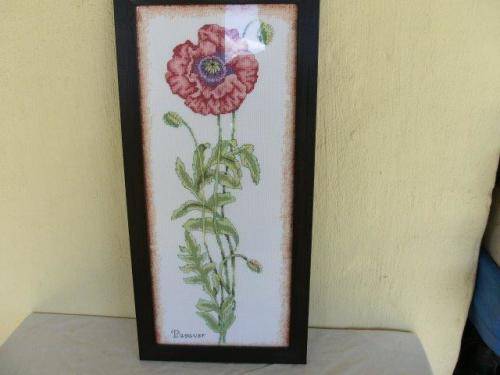 Single red floarl  taperstry framed behind glass