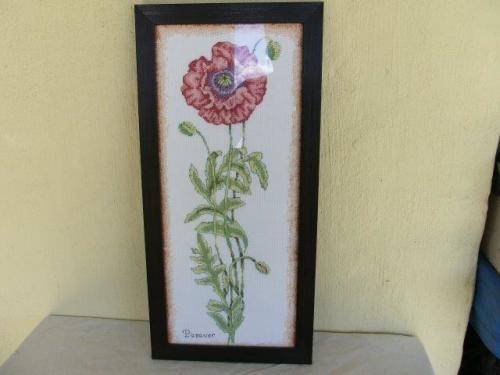 Single red floarl  taperstry framed behind glass