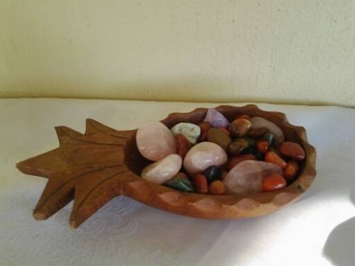 small wooden pineapple bowl filled with some semi preicous stones