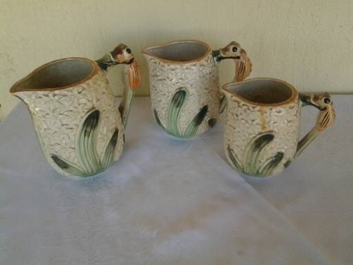 A set of three vintage bee style porcelain decorative porcelain jugs