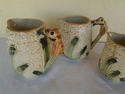 A set of three vintage bee style porcelain decorative porcelain jugs