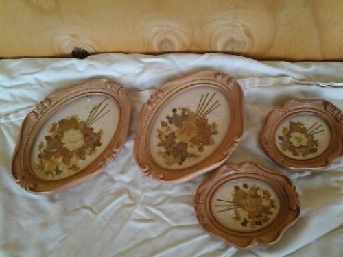 a lot of small pretty hard plastic vintage ornate frames with dried flowers inside