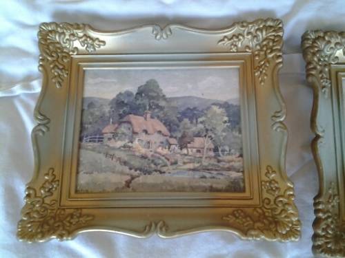 A pair of small pretty hard plastic ornate frames with painted home scenes