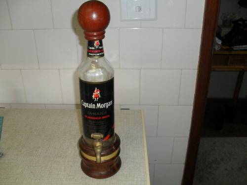 A CAPTAIN MORGAN GLASS BOTTLE DISPENSER / DECANTER / with a brass  TAP -mounted on wood.