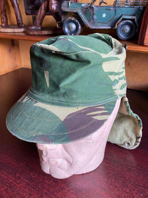 RHODESIAN CAMO FLAP CAP-INSIDE RING MEASURES 52 CM-THIS CAP IS IN VERY GOOD CONDITION-HARDLY WORN