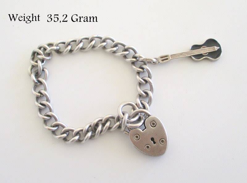 A HEAVY SILVER  BRACELET WITH A LOCKET AND SILVER GUITAR---Weight 35,2 Gram