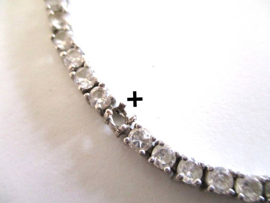 A SOLID SILVER TENNIS BRACELET WITH A WELL MADE CLASP--PLEASE SEE ALL IMAGES