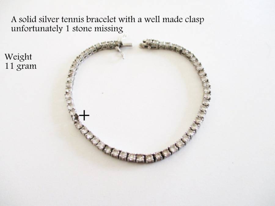 A SOLID SILVER TENNIS BRACELET WITH A WELL MADE CLASP--PLEASE SEE ALL IMAGES