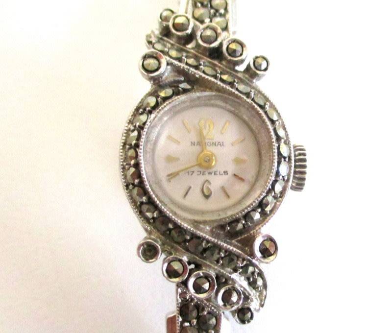 A STERLING SILVER MARCASITE (ALL INTACT) WATCH IN WORKING ORDER AND KEEPING TIME