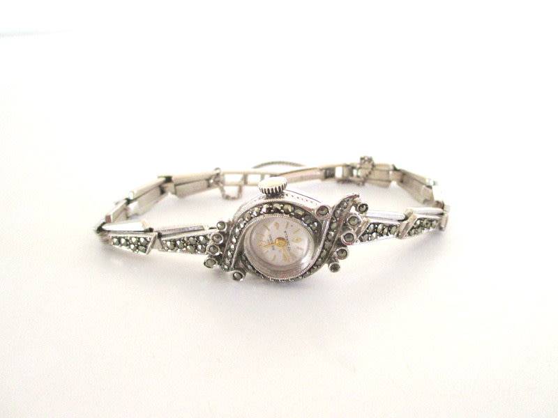 A STERLING SILVER MARCASITE (ALL INTACT) WATCH IN WORKING ORDER AND KEEPING TIME
