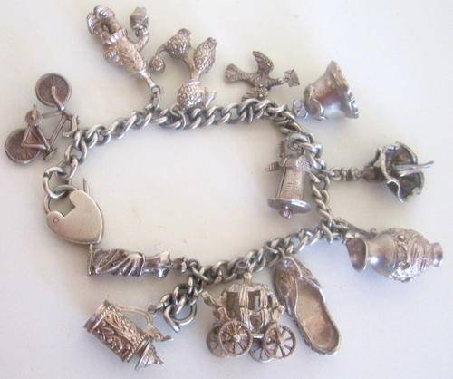 A VINTAGE SILVER CHUNKY CHARM BRACELET WITH 12 CHARMS.---97,5 GRAM