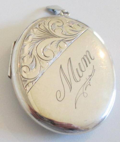 A LARGE HALLMARKED SILVER LOCKET