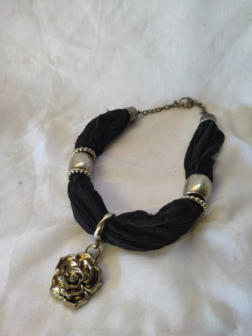A stunning black scarf necklace with big rose pendant