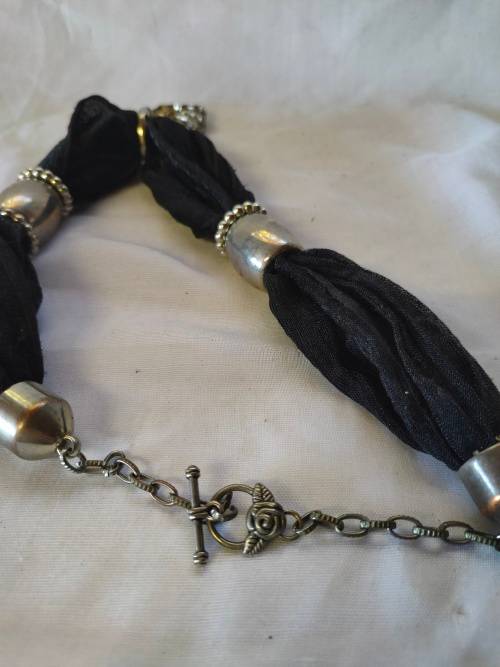 A stunning black scarf necklace with big rose pendant