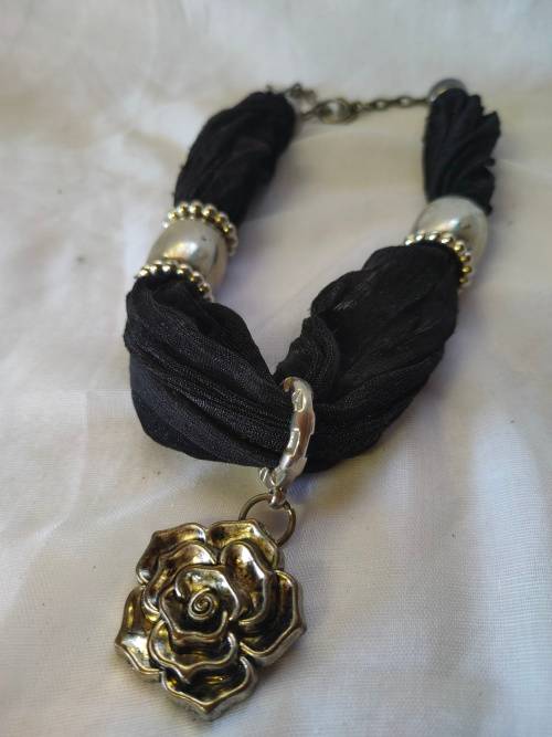 A stunning black scarf necklace with big rose pendant