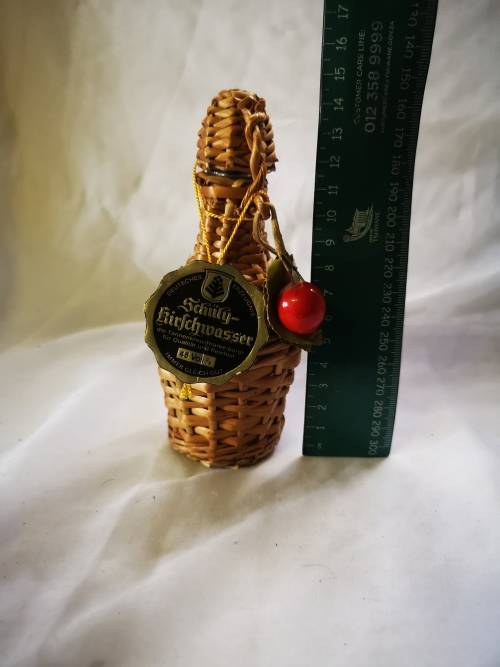 A small bottle of liquor in a beautiful woven basket - still sealed